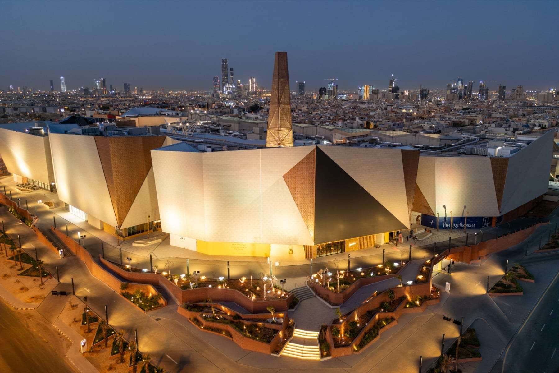 Solitaire Mall in Riyadh from the air at dusk, its faceted facade lit by ARAK
