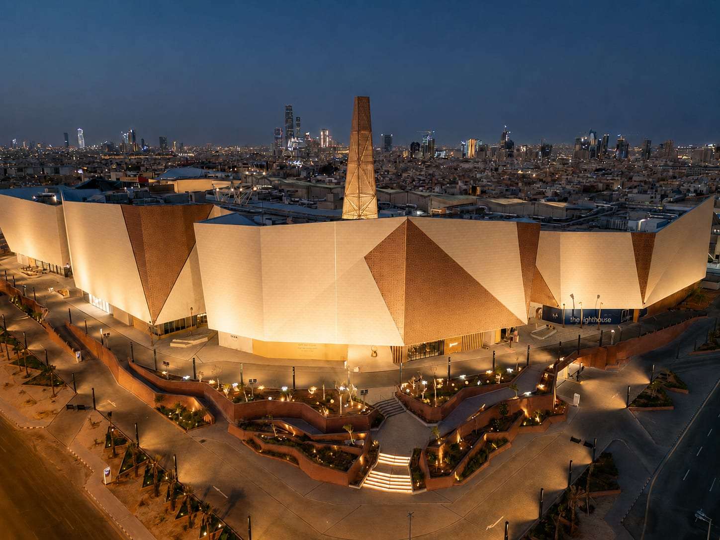 Solitaire Mall in Riyadh from the air at dusk, its faceted facade lit by ARAK
